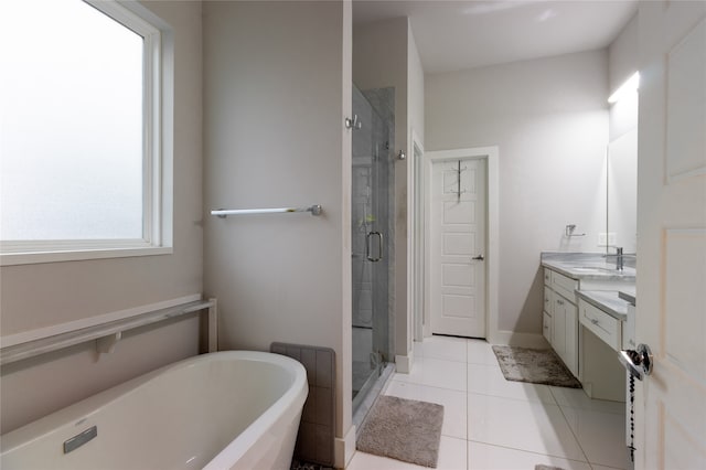 full bath with a stall shower, tile patterned flooring, a freestanding tub, and vanity