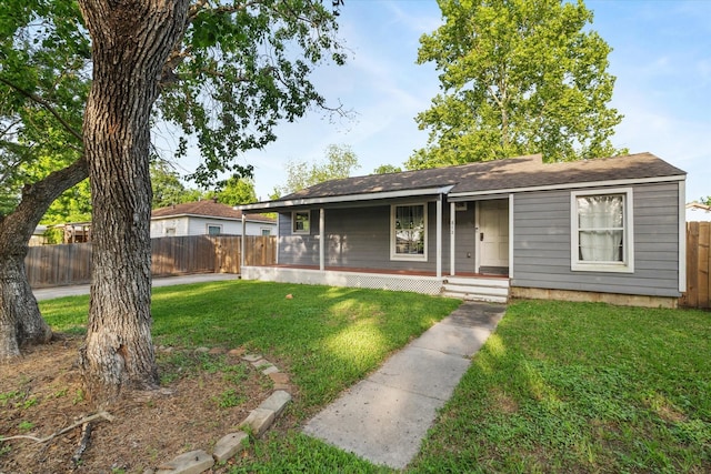 view of front of property with a porch, a front lawn, and fence