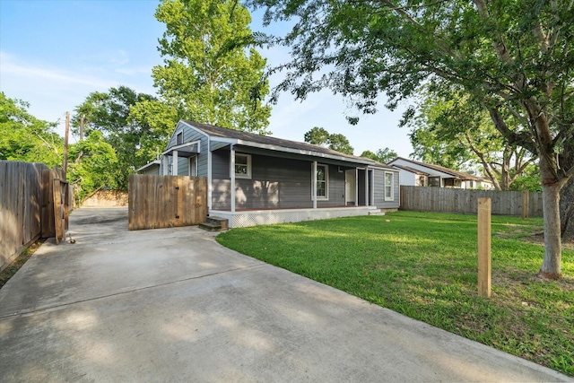 view of front of home with fence, a front lawn, and concrete driveway