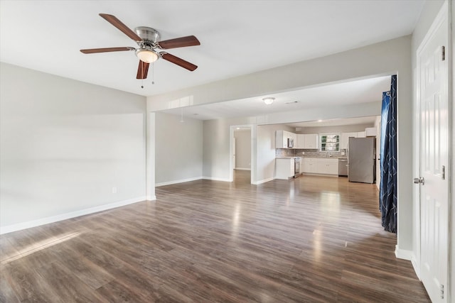 unfurnished living room featuring dark wood-style floors, baseboards, and ceiling fan