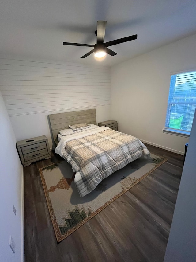 bedroom featuring baseboards, wood finished floors, and ceiling fan