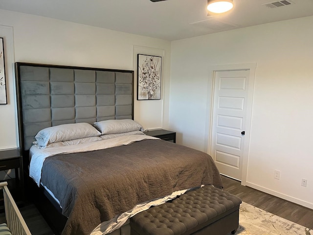 bedroom featuring wood finished floors, visible vents, and baseboards