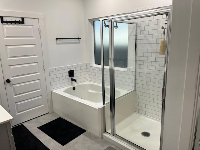 full bathroom with vanity, a shower stall, and a bath