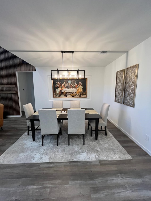 dining space with wood finished floors, visible vents, and baseboards