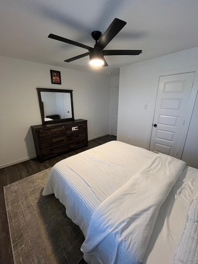 bedroom with dark wood-style flooring, ceiling fan, and baseboards