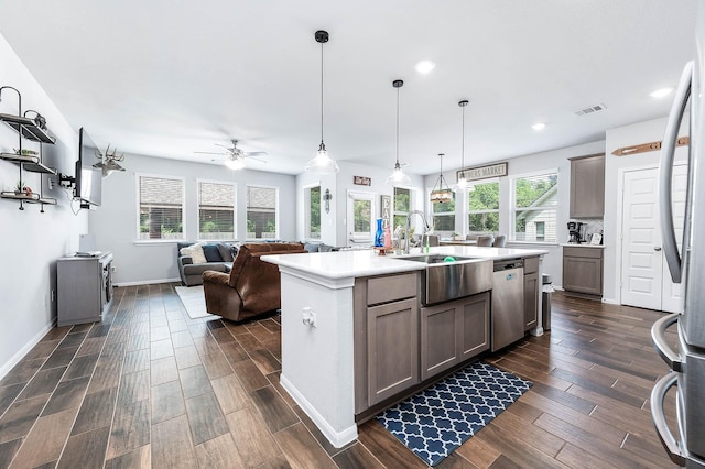 kitchen with appliances with stainless steel finishes, visible vents, ceiling fan, light countertops, and dark wood finished floors