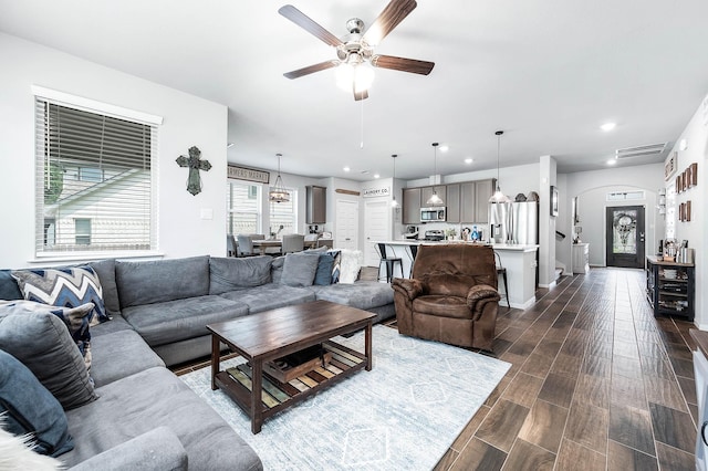 living area with recessed lighting, dark wood-style flooring, a ceiling fan, visible vents, and arched walkways