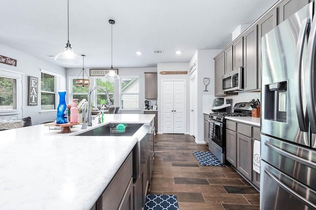 kitchen with tasteful backsplash, stainless steel appliances, light countertops, recessed lighting, and dark wood-type flooring