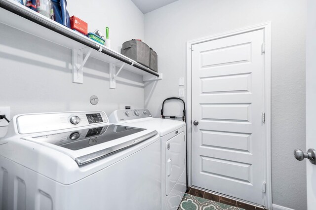laundry room with separate washer and dryer, laundry area, and baseboards