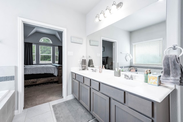 bathroom with double vanity, ensuite bathroom, tile patterned flooring, and a sink