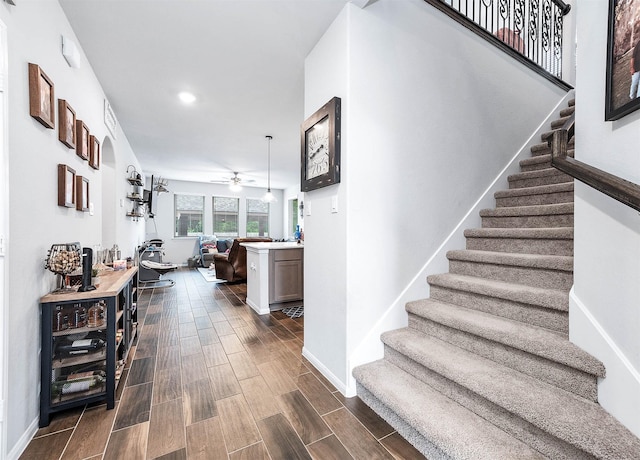 stairs featuring recessed lighting, wood finished floors, baseboards, a ceiling fan, and wine cooler