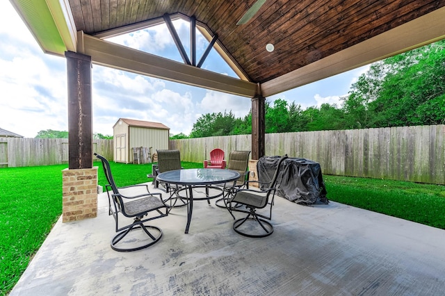 view of patio with an outdoor structure, a shed, outdoor dining space, and a fenced backyard