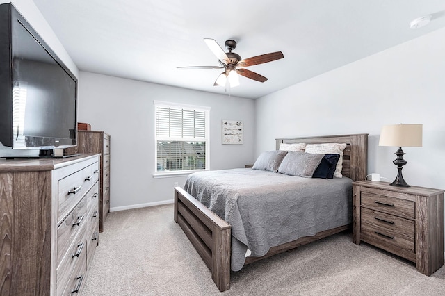 bedroom featuring baseboards, light carpet, and ceiling fan