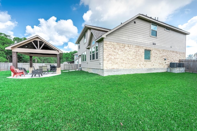 back of house with a lawn, a gazebo, and brick siding
