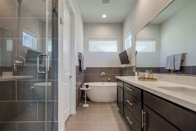 107 Knightsbridge Park Ln, Houston, TX 77018 - full bathroom featuring tile walls, double vanity, tile patterned floors, and plenty of natural light