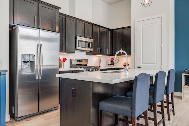 107 Knightsbridge Park Ln, Houston, TX 77018 - kitchen featuring light wood finished floors, a sink, stainless steel appliances, a breakfast bar area, and light countertops