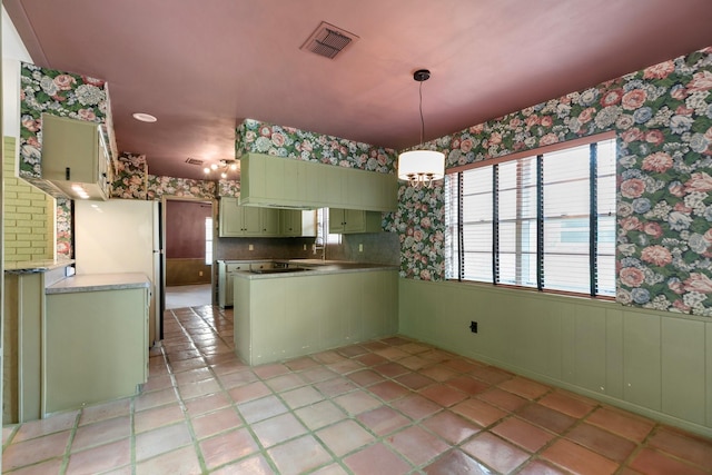 kitchen with visible vents, a peninsula, wallpapered walls, plenty of natural light, and green cabinetry