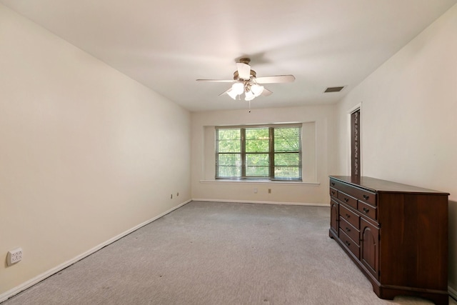 unfurnished room featuring baseboards, ceiling fan, light carpet, and visible vents