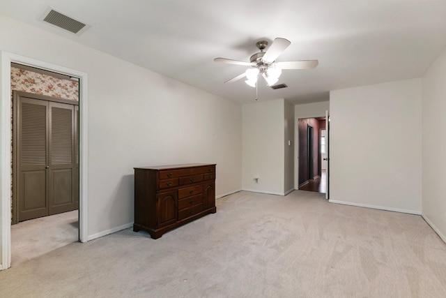 unfurnished bedroom featuring light colored carpet, baseboards, and visible vents