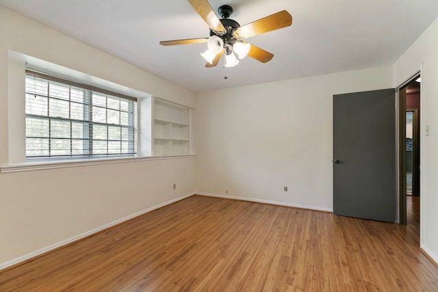 unfurnished room featuring baseboards, ceiling fan, and wood finished floors