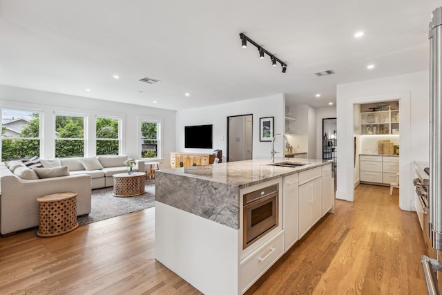 1202 Ashland St, Houston, TX 77008 - kitchen with a sink, open floor plan, white cabinetry, a kitchen island with sink, and recessed lighting