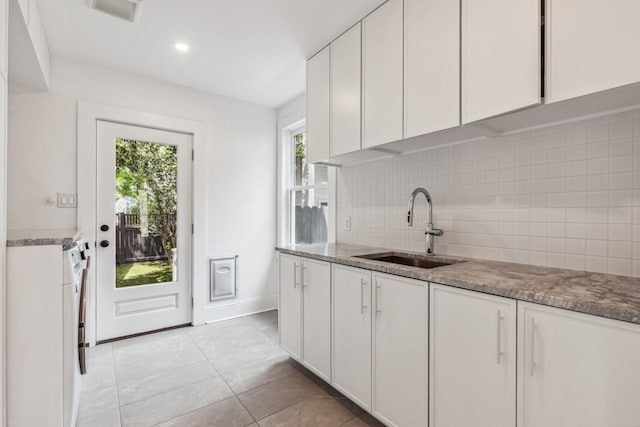 1202 Ashland St, Houston, TX 77008 - kitchen with a sink, backsplash, white cabinetry, light tile patterned flooring, and recessed lighting
