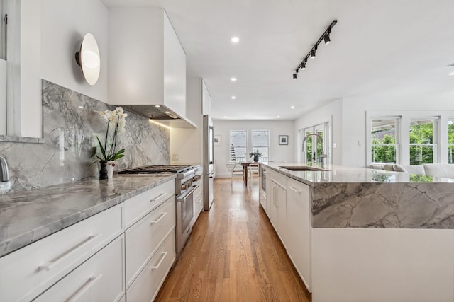 1202 Ashland St, Houston, TX 77008 - kitchen with a sink, high end appliances, light wood finished floors, light stone countertops, and decorative backsplash