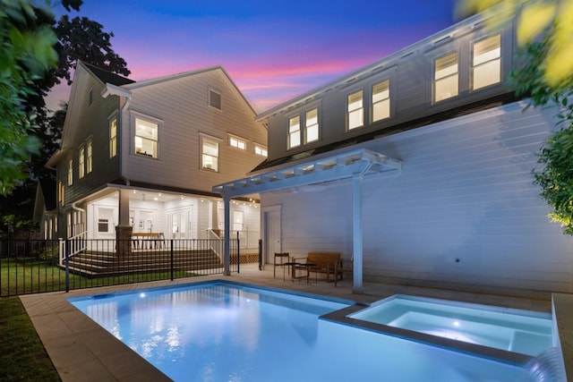 1202 Ashland St, Houston, TX 77008 - back of house at dusk featuring a pergola, a patio area, fence, and a pool with connected hot tub