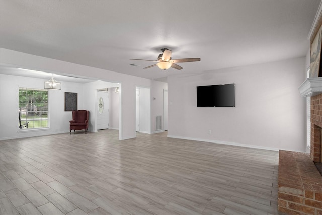 unfurnished living room with light wood finished floors, visible vents, ceiling fan, and a fireplace