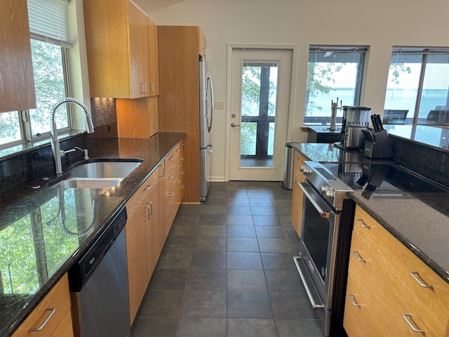 20998 Kiva Cir, Flint, TX 75762 - kitchen with brown cabinets, dark stone countertops, stainless steel appliances, and a sink