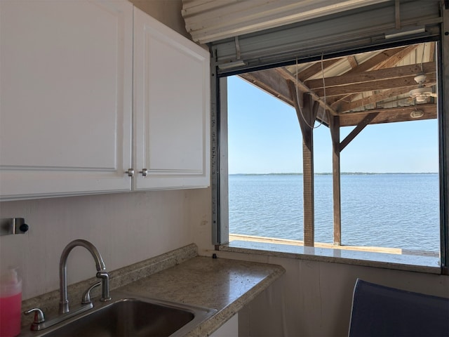 20998 Kiva Cir, Flint, TX 75762 - kitchen with white cabinets, a sink, and a water view
