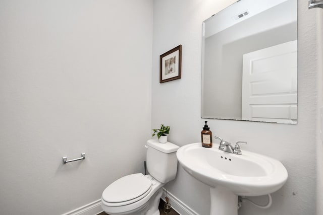 2242 Bayleaf Manor Dr, Manvel, TX 77578 - half bathroom with toilet, baseboards, visible vents, and a sink