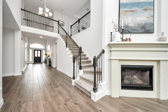 2242 Bayleaf Manor Dr, Manvel, TX 77578 - foyer with an inviting chandelier, stairs, baseboards, wood finished floors, and a towering ceiling