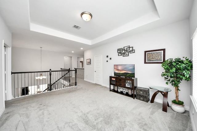 2242 Bayleaf Manor Dr, Manvel, TX 77578 - living area with visible vents, baseboards, a tray ceiling, carpet, and an upstairs landing