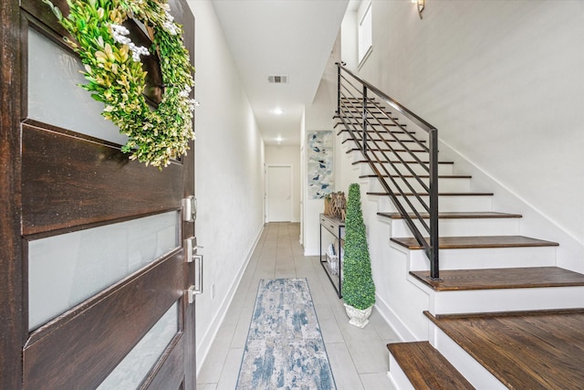 stairway with tile patterned floors, visible vents, recessed lighting, and baseboards