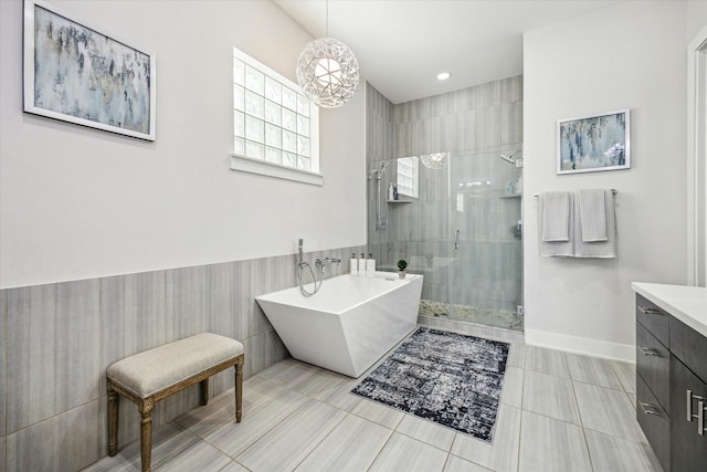 bathroom with a shower stall, a soaking tub, a chandelier, tile patterned floors, and vanity