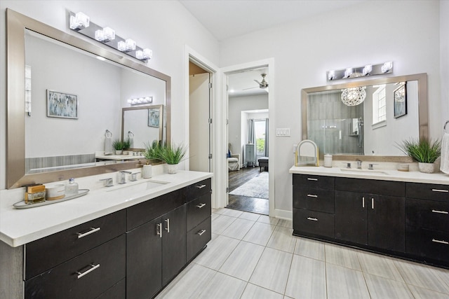 ensuite bathroom featuring two vanities, a ceiling fan, ensuite bath, and a sink