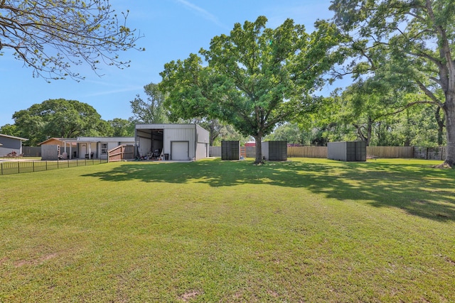 1315 Kilgore Rd, Baytown, TX 77520 - view of yard with an outdoor structure, a fenced backyard, and a detached garage