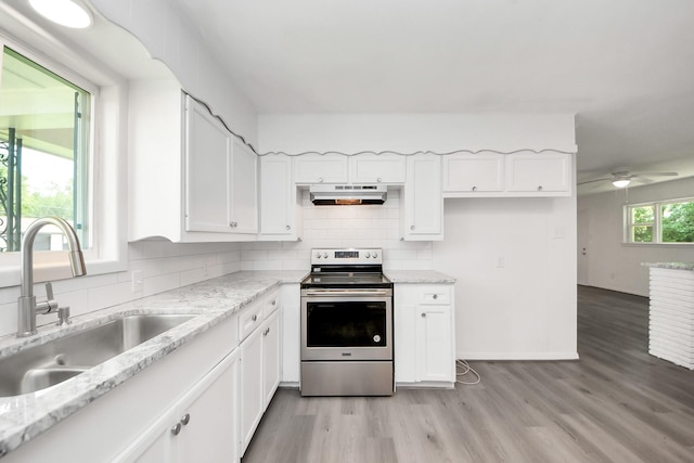 206 Hill St, Dayton, TX 77535 - kitchen with white cabinetry, light wood-type flooring, stainless steel range with electric cooktop, and a sink