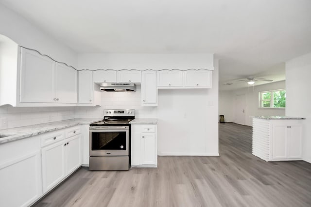 206 Hill St, Dayton, TX 77535 - kitchen with under cabinet range hood, light wood-style floors, stainless steel electric range oven, a ceiling fan, and white cabinets