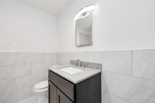 206 Hill St, Dayton, TX 77535 - bathroom featuring tile walls, wainscoting, toilet, and vanity