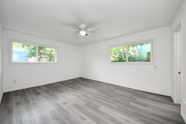 206 Hill St, Dayton, TX 77535 - unfurnished bedroom with wood finished floors, baseboards, a ceiling fan, and multiple windows