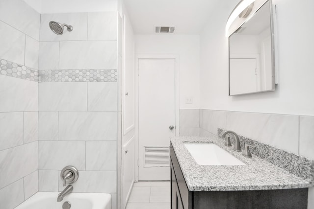 206 Hill St, Dayton, TX 77535 - bathroom featuring shower / bathtub combination, tile walls, visible vents, and vanity