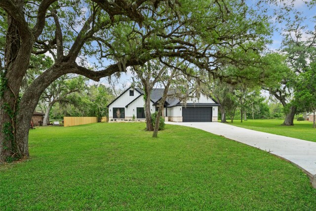 view of front of home featuring a garage, board and batten siding, a front lawn, and driveway