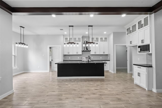 kitchen with a sink, black microwave, dark countertops, recessed lighting, and backsplash