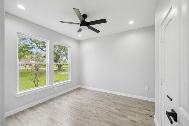 spare room featuring light wood-type flooring, a ceiling fan, recessed lighting, and baseboards