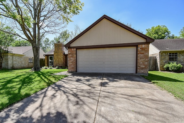 view of front of property with a front yard, a garage, driveway, brick siding, and fence