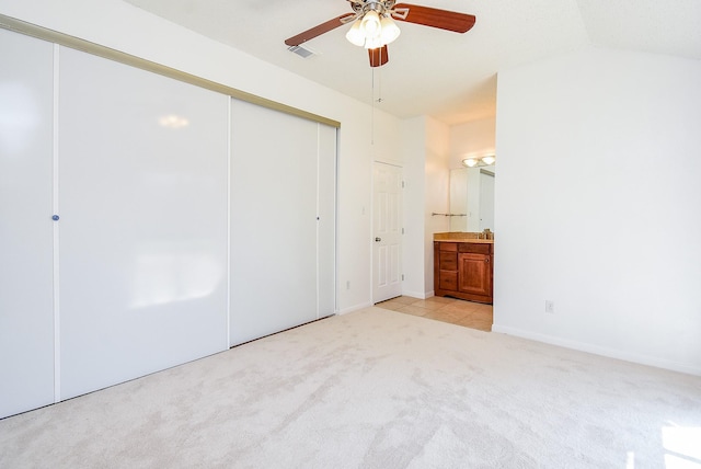 unfurnished bedroom featuring light colored carpet, visible vents, baseboards, a closet, and ensuite bath
