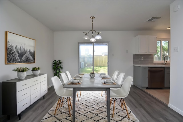 dining room with dark wood finished floors, baseboards, visible vents, and an inviting chandelier