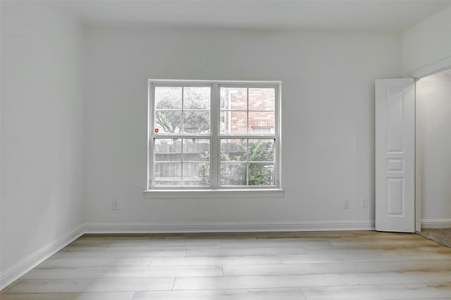 unfurnished room featuring wood finished floors and baseboards